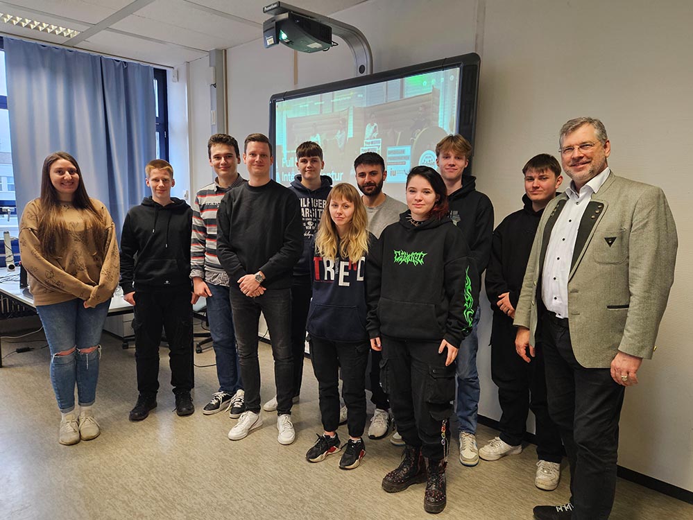  Die Kursteilnehmenden mit Jasmin Reiff (Technical Director) links im Bild, Fynn Kremer (Frontend Developer) mittig im Bild und Schulleiter, Edelbert Jansen rechts im Bild.